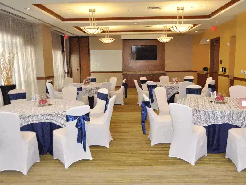 Navy and white decor with white rosette overlays and navy satin table cloths and chair sashes