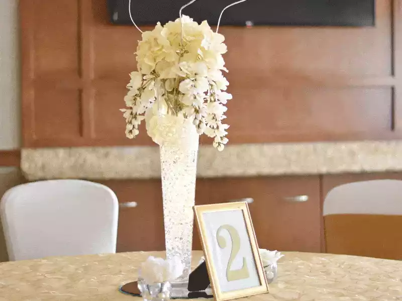 Glass vase with gel beads and white flowers for table centerpiece