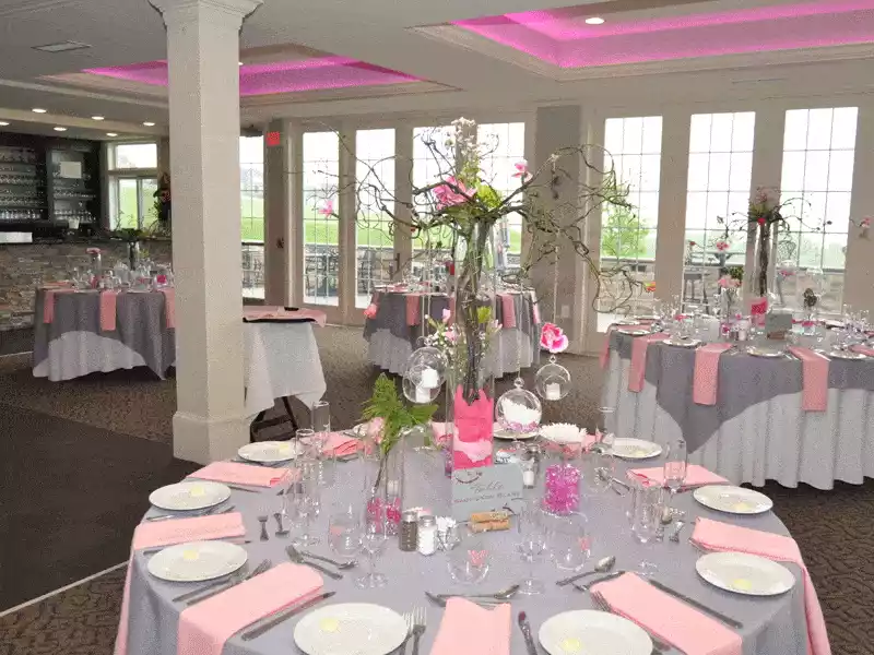 Pink and grey wedding dcorations with branches in vases as centerpieces