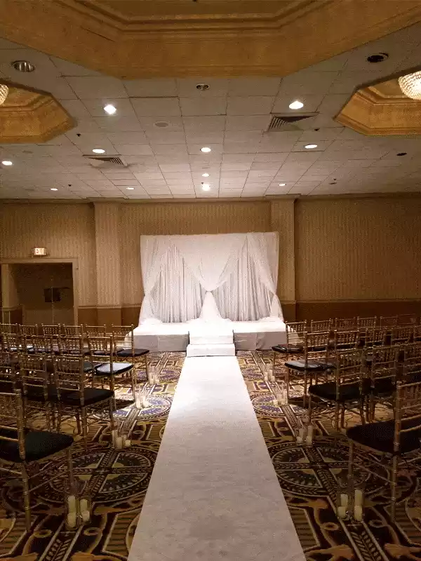 Draping for wedding ceremony with carpet runner and candles in vases