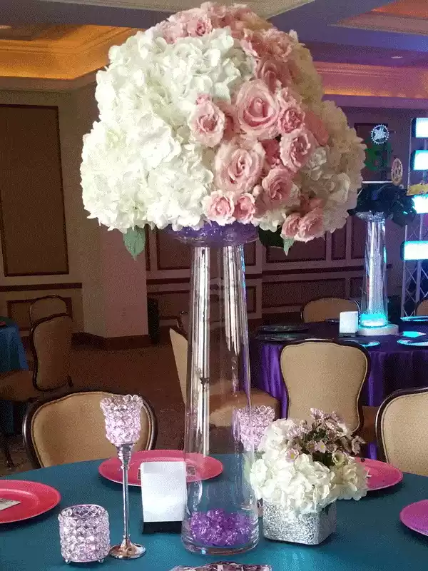 Tall pink and white flowers on top of glass vase centerpiece for wedding