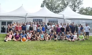 Employees gathered for a group photo a their company summer picnic
