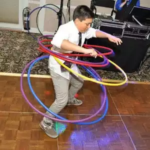 A young kid using multiple hula hoops at one time at a PartyMasterz event