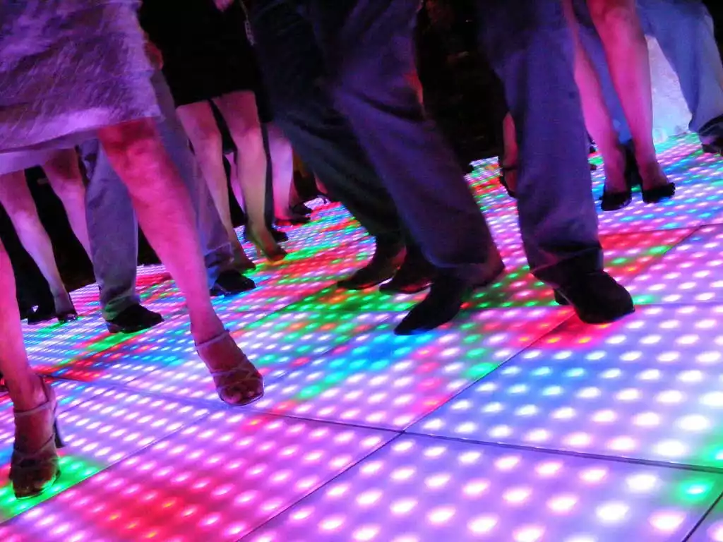 People dancing on an LED dance floor