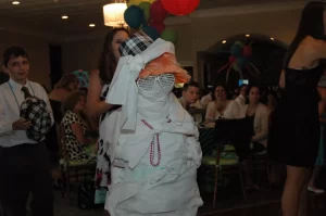 A kid covered in toilet paper for the mummy wrap game at a PartyMasterz event