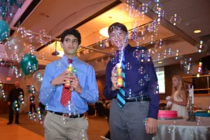 Two young guys making bubbles with bubble guns