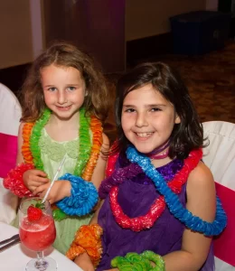 Two kids wearing leis at a party