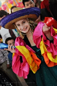 Girl dressed in conga sleeves, sombrero and holding maracas