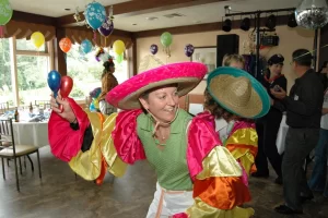 Woman wearing conga sleeve and sombrero dancing at a party