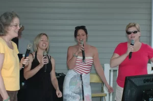 Group of women singing karaoke at a party