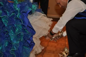 A father changing his daughters shoes at her quinceanera