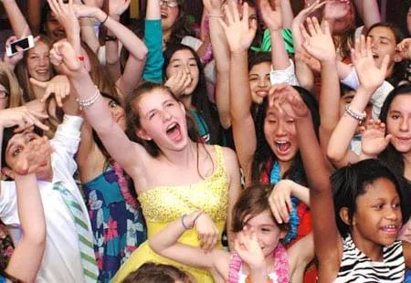 Girl in yellow dress surrounded by friends dancing