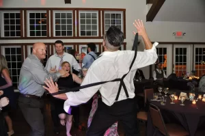 Man dancing at wedding and pulling off suspenders
