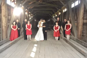 Bridal party standing inside a covered bridge