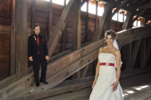 Groom looking at beautiful bride while standing inside a covered bridge
