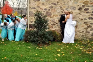 A bridal peeking at the bride and groom kissing
