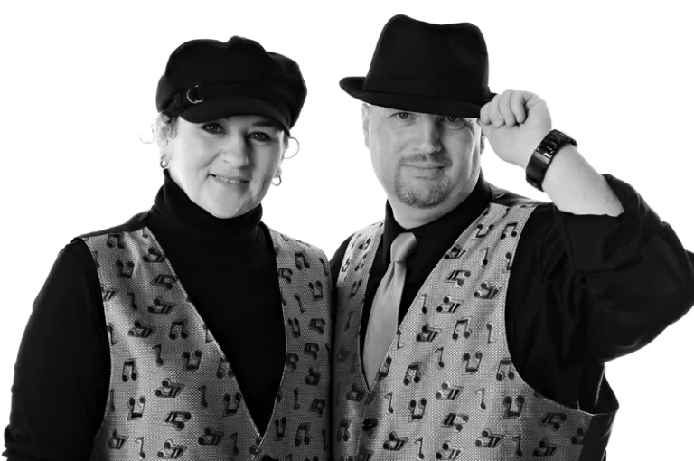 award winning talent Black and white photo of couple both wearing hats and music note vests
