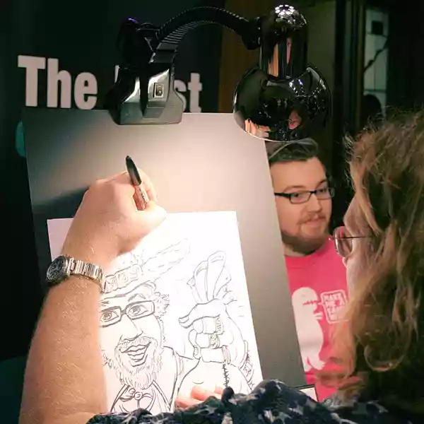 a caricature artist drawing a man with a black marker at a partymasterz event