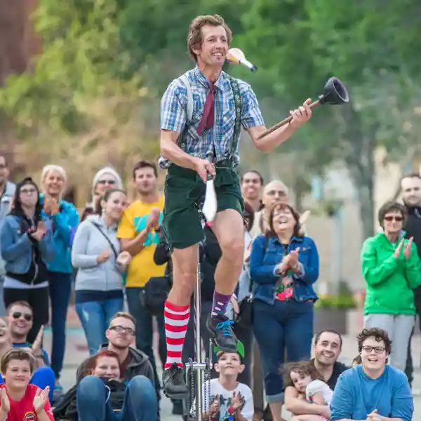 Guy on a unicycle juggling a knife and plunger